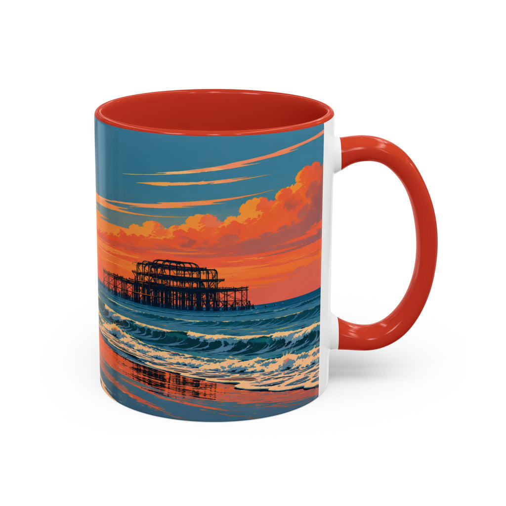A ceramic mug with a red handle and red interior, featuring a printed beach scene at sunset with blue ocean waves, orange clouds, and a pier. The mug is shown on a clean white background.